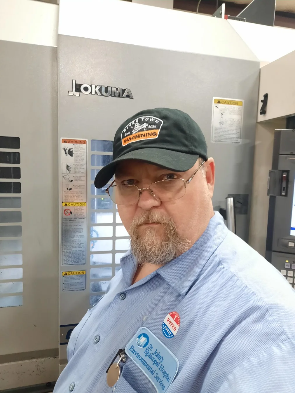Joe Robak beside an Okuma CNC machine